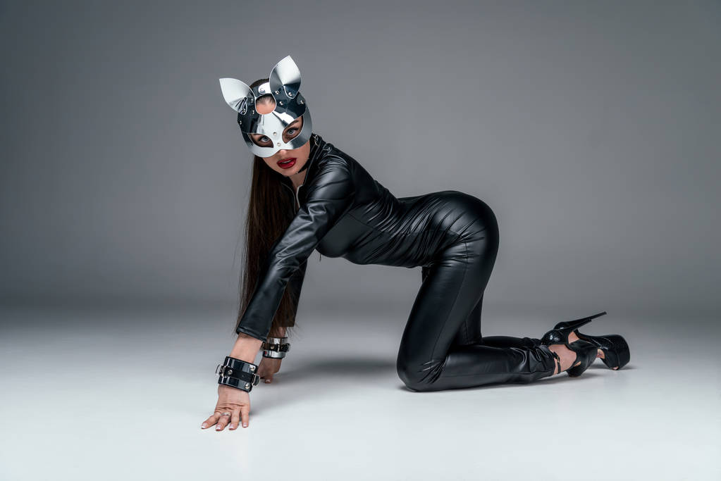 verführerische junge Frau im sexy Catsuit auf grauem Hintergrund - Foto, Bild