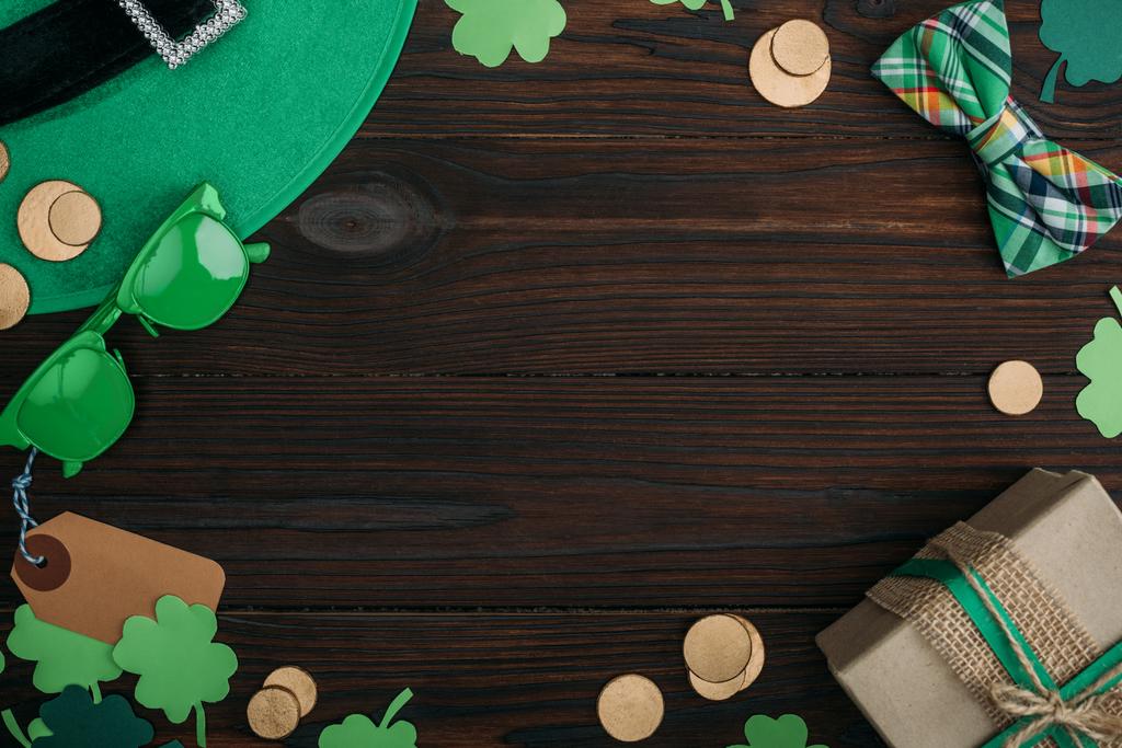 το Top view χρυσά νομίσματα, κιβώτιο δώρων και πράσινα αξεσουάρ στο ξύλινο τραπέζι - Φωτογραφία, εικόνα