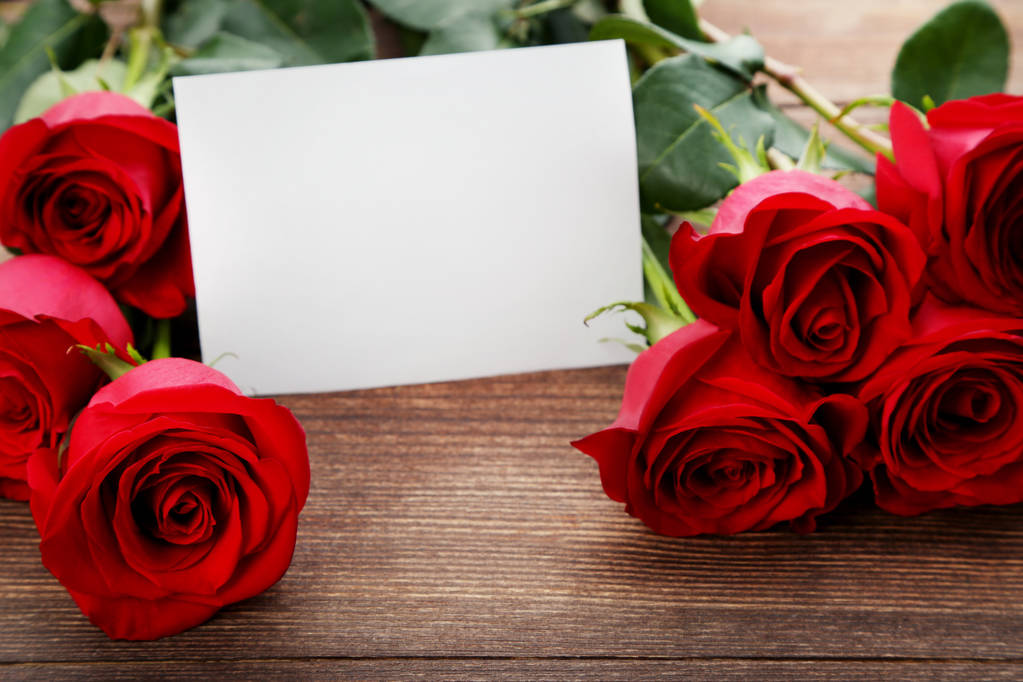 Punaisten ruusujen kimppu tyhjällä paperiarkilla
  - Valokuva, kuva