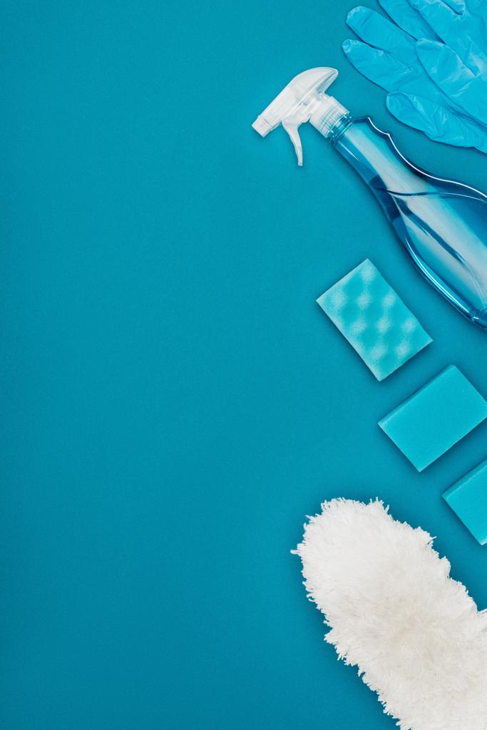 vista superior de luvas de borracha e esponjas de lavagem para limpeza isoladas em azul
 - Foto, Imagem