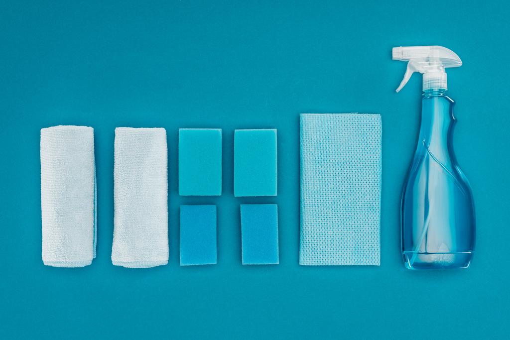 vista superior de trapos, esponjas de lavagem e frasco de spray isolado em azul
 - Foto, Imagem