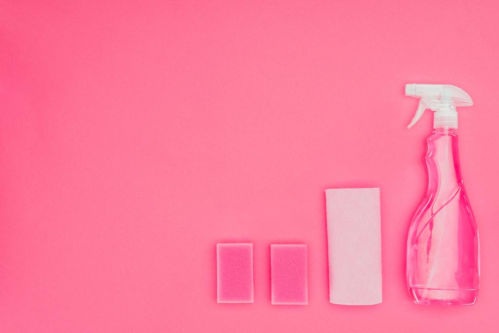 Ansicht von rosa Waschschwämmen, Lappen und Sprühflasche isoliert auf rosa - Foto, Bild