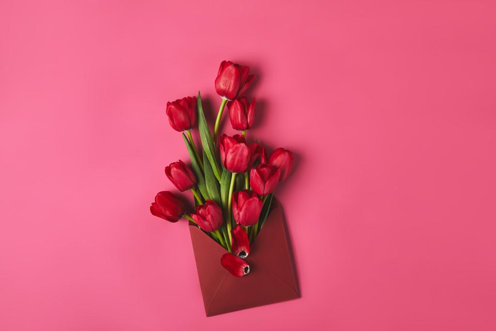 вид зверху на червоні тюльпани в конверті на рожевому, концепція Дня матері
 - Фото, зображення