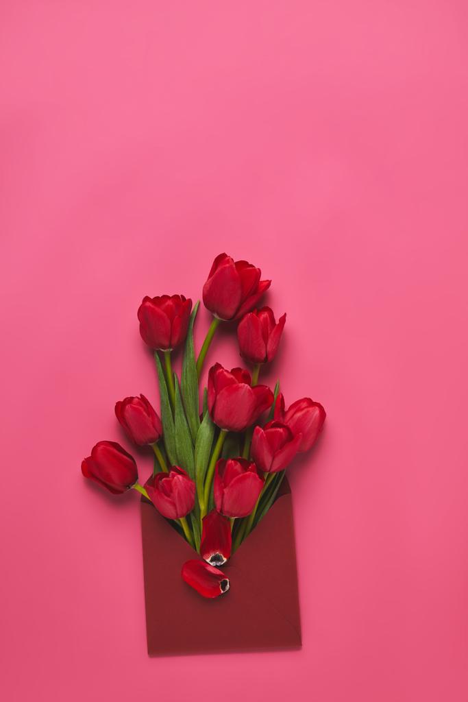 top view of red tulips in envelope on pink, mothers day concept - Photo, Image