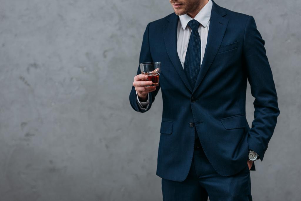 Oříznout záběr pohledný podnikatel se sklenkou whisky - Fotografie, Obrázek