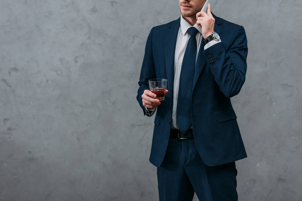 Schnappschuss von Geschäftsmann mit Glas Whiskey am Telefon - Foto, Bild