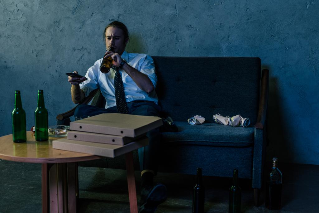 депресивний алкоголік залежний чоловік у білій сорочці дивитися телевізор і пити пиво після роботи
 - Фото, зображення