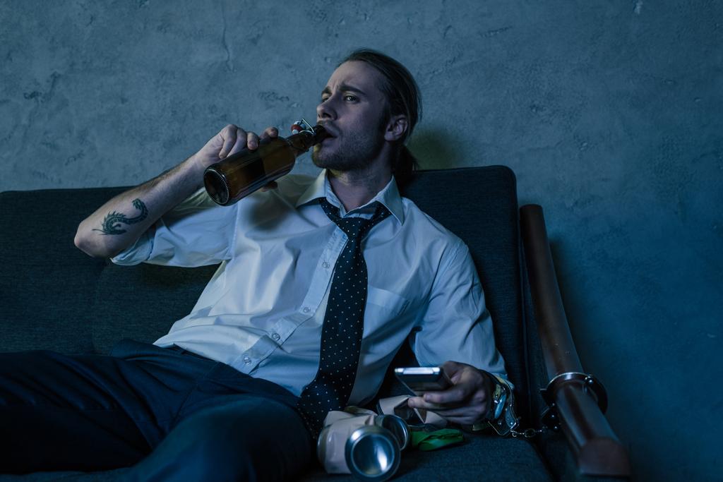 若いアルコール中毒テレビを見ていると、仕事の後のビールを飲み白シャツの男 - 写真・画像