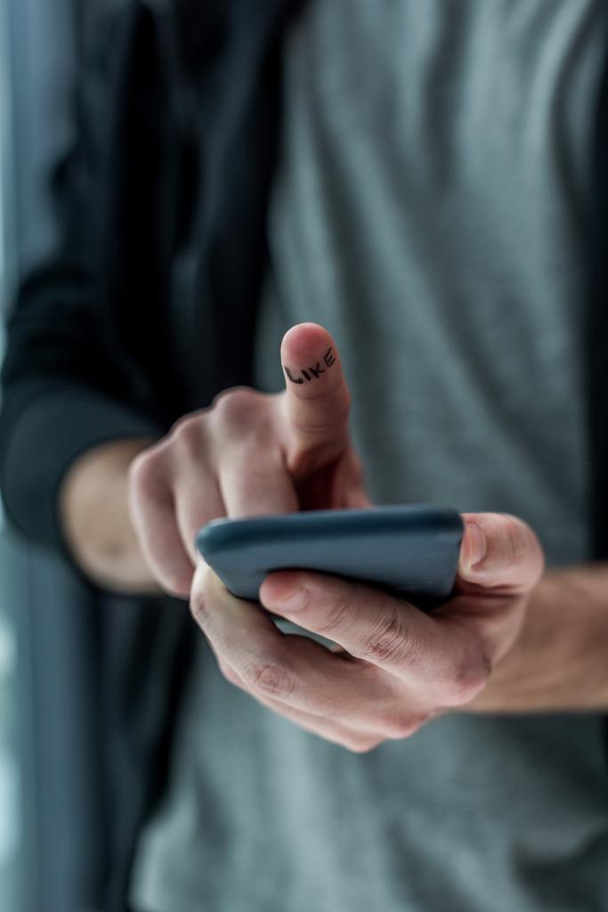 περικοπεί shot του ανθρώπου αγγίζοντας την οθόνη smartphone με σαν λέξη στο δάχτυλο, τηλέφωνο έννοιας εθισμού - Φωτογραφία, εικόνα