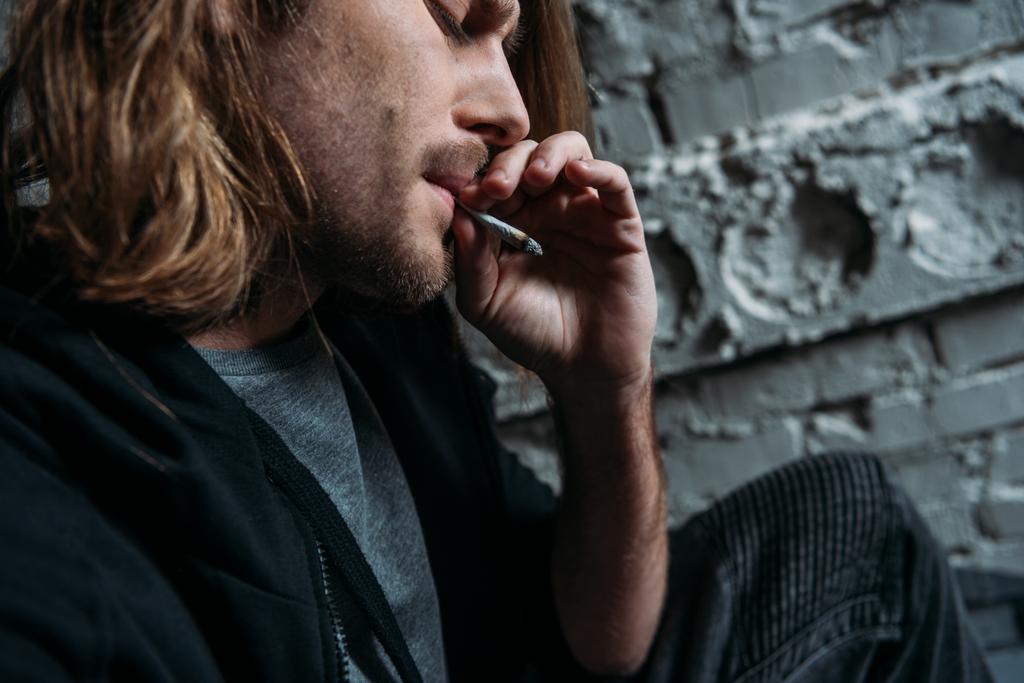 plan rapproché d'un jeune homme fumant une cigarette
 - Photo, image