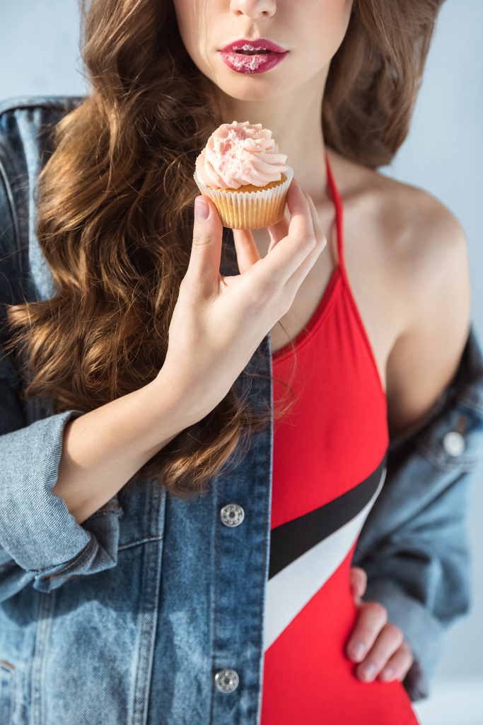 immagine ritagliata di ragazza sexy in costume da bagno rosso in possesso di cupcake isolato su grigio
 - Foto, immagini