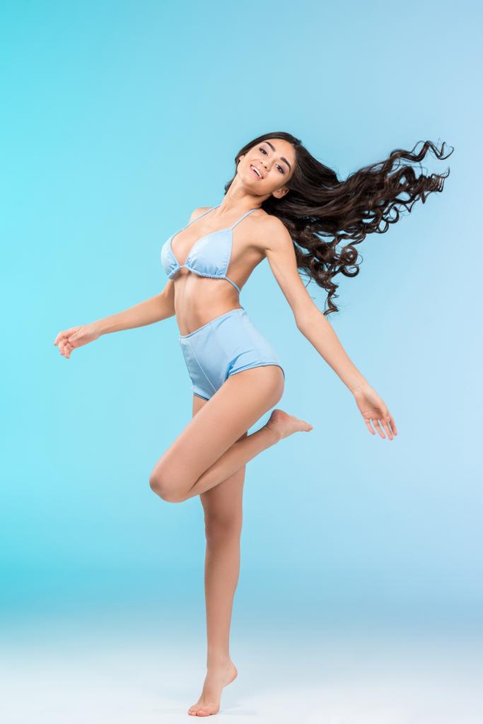 hermosa chica morena feliz posando en bikini, aislado en azul
  - Foto, imagen