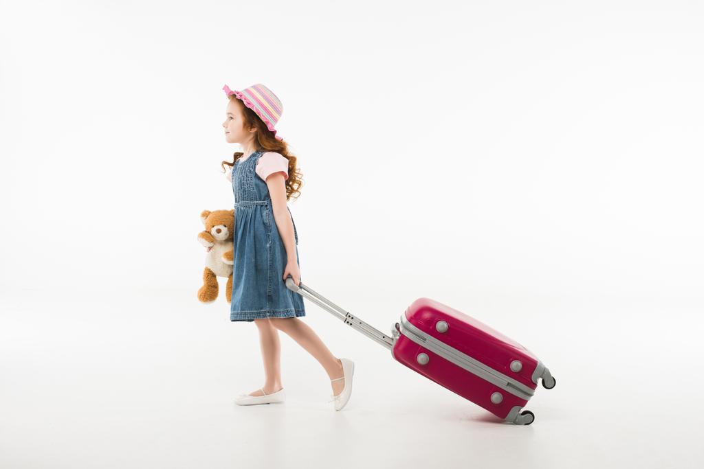Petit touriste élégant en chapeau avec ours en peluche et valise isolée sur blanc, concept de voyage
 - Photo, image