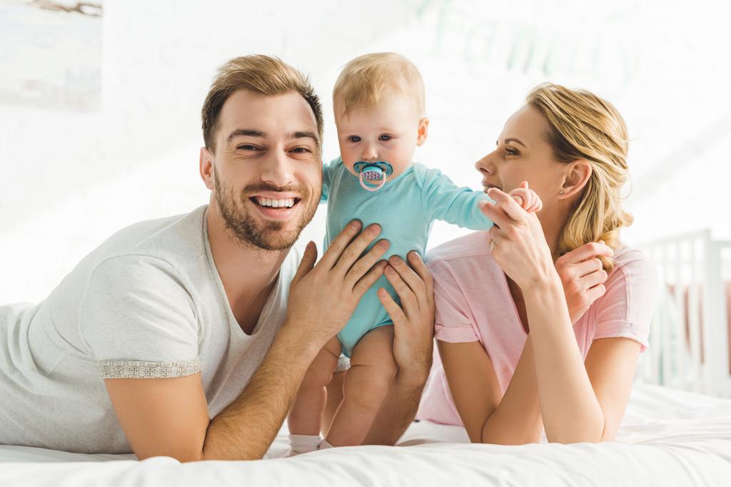 Feliz familia joven e hija lactante con maniquí bebé
 - Foto, Imagen