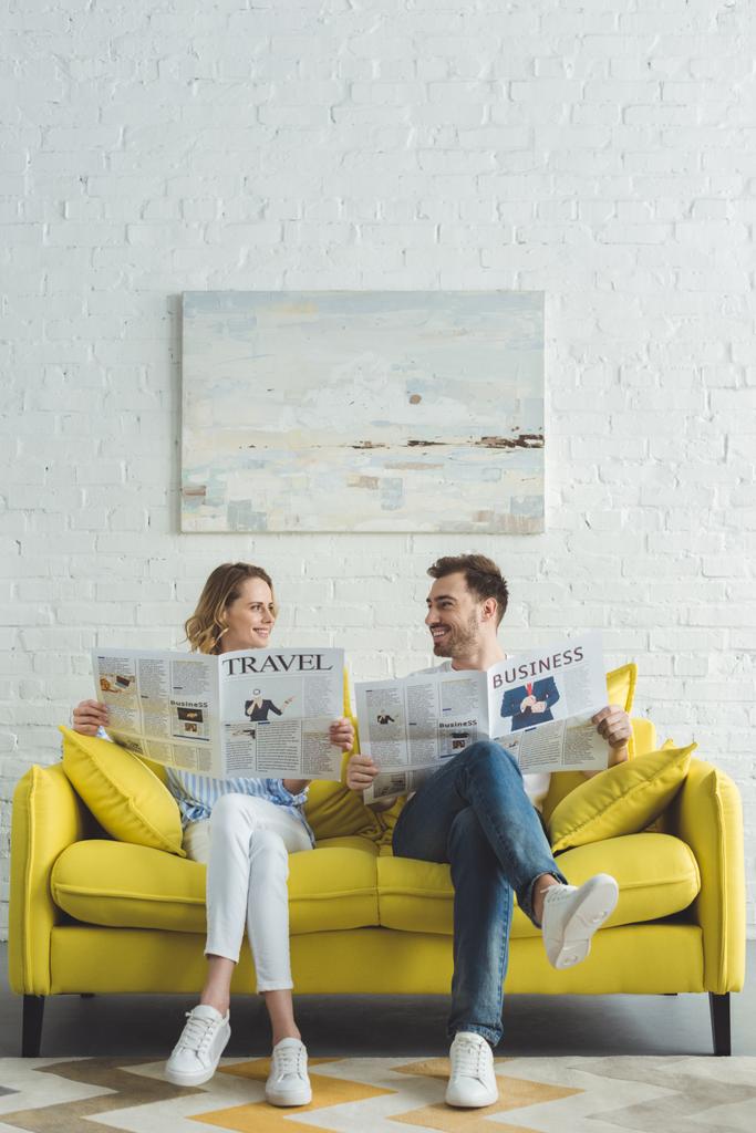 Empresário elegante com namorada lendo jornais sobre negócios e viagens
  - Foto, Imagem
