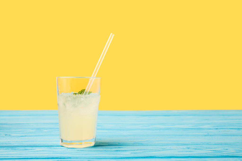 青緑色の木製テーブルの上にストローとガラスの新鮮な冷たい夏の飲み物   - 写真・画像