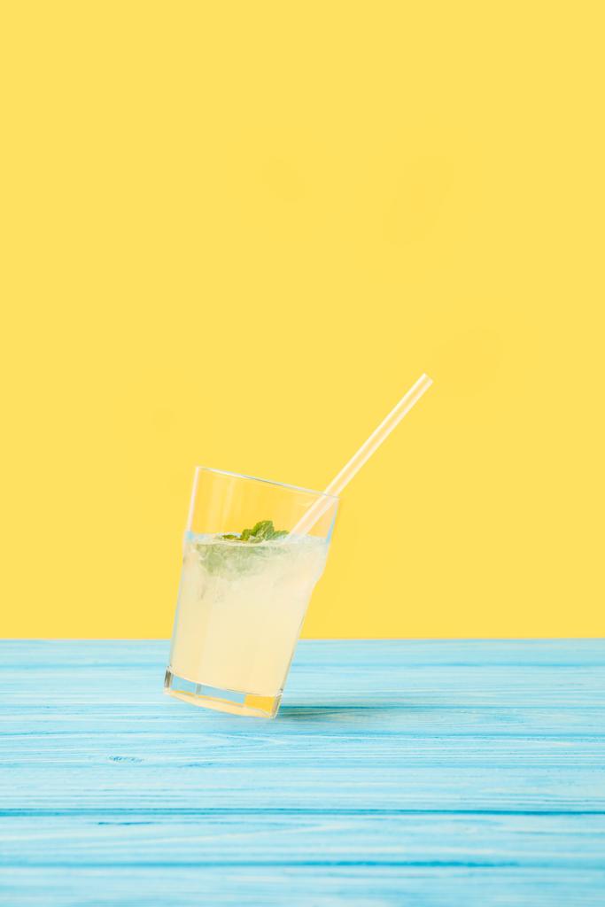 Glas mit frischem kalten Sommercocktail und Trinkhalm auf gelb - Foto, Bild