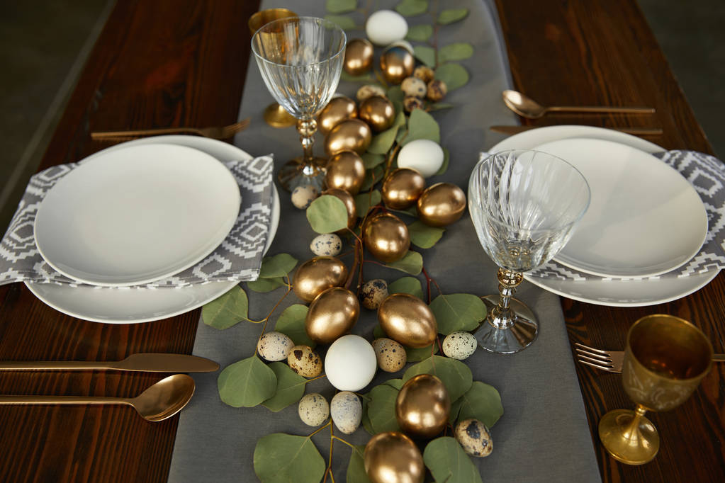 высокий угол обзора золотых пасхальных яиц на деревянном столе в ресторане
 - Фото, изображение