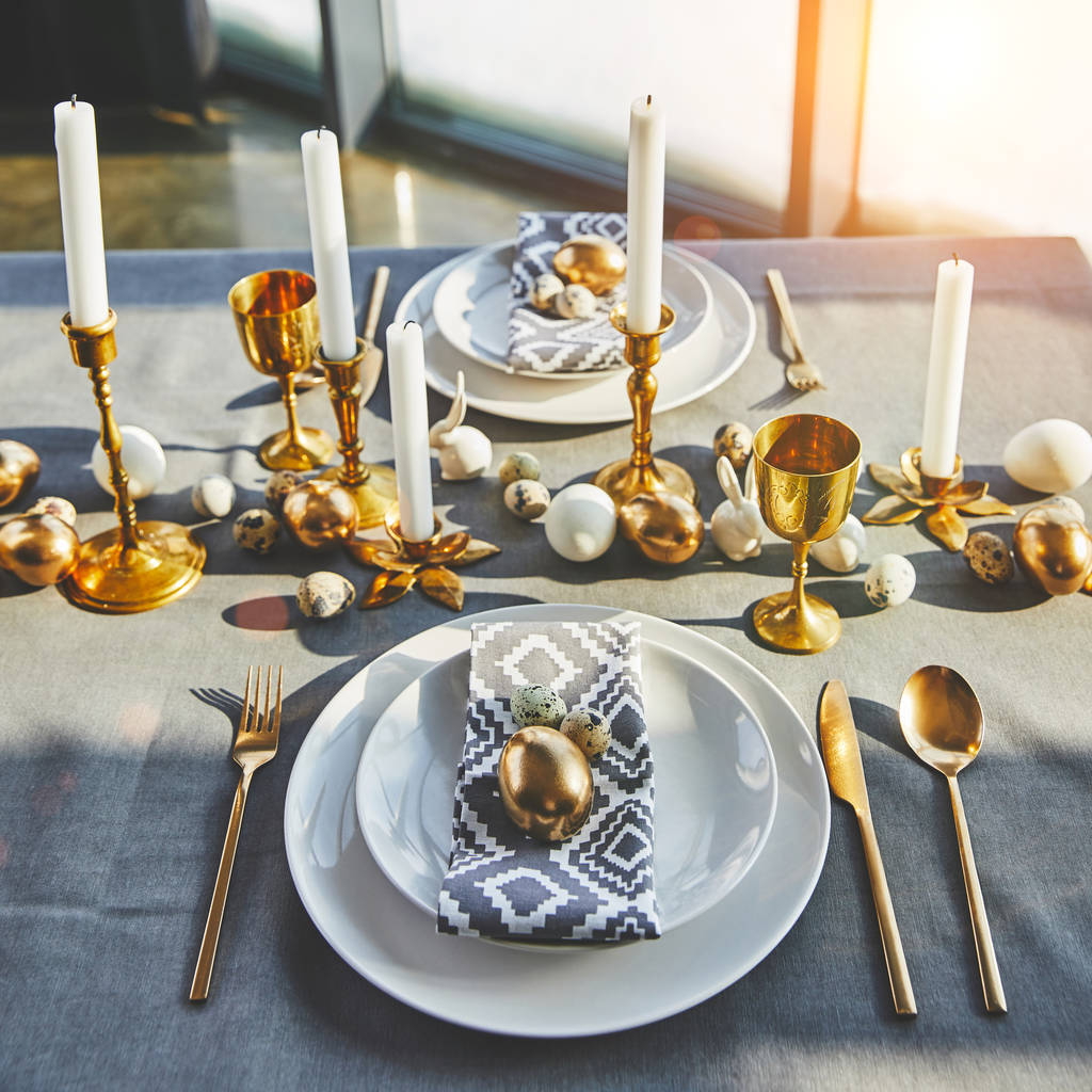 Paaseieren en kaarsen op feestelijke tafel met zonlicht - Foto, afbeelding