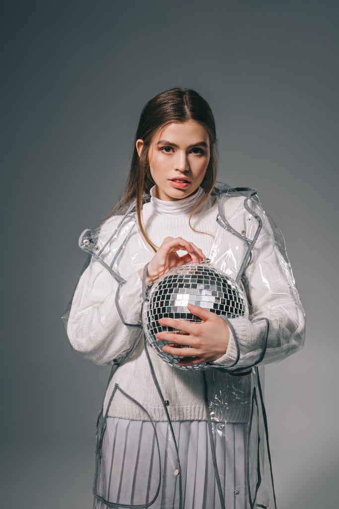 portrait of stylish young woman with disco ball in hands isolated on grey - Photo, Image