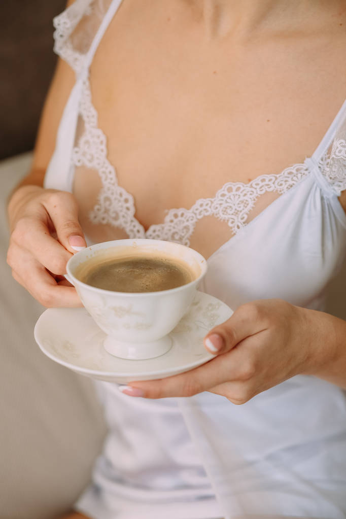 コーヒーを飲みながらベッドの上の女性の寝室 - 写真・画像