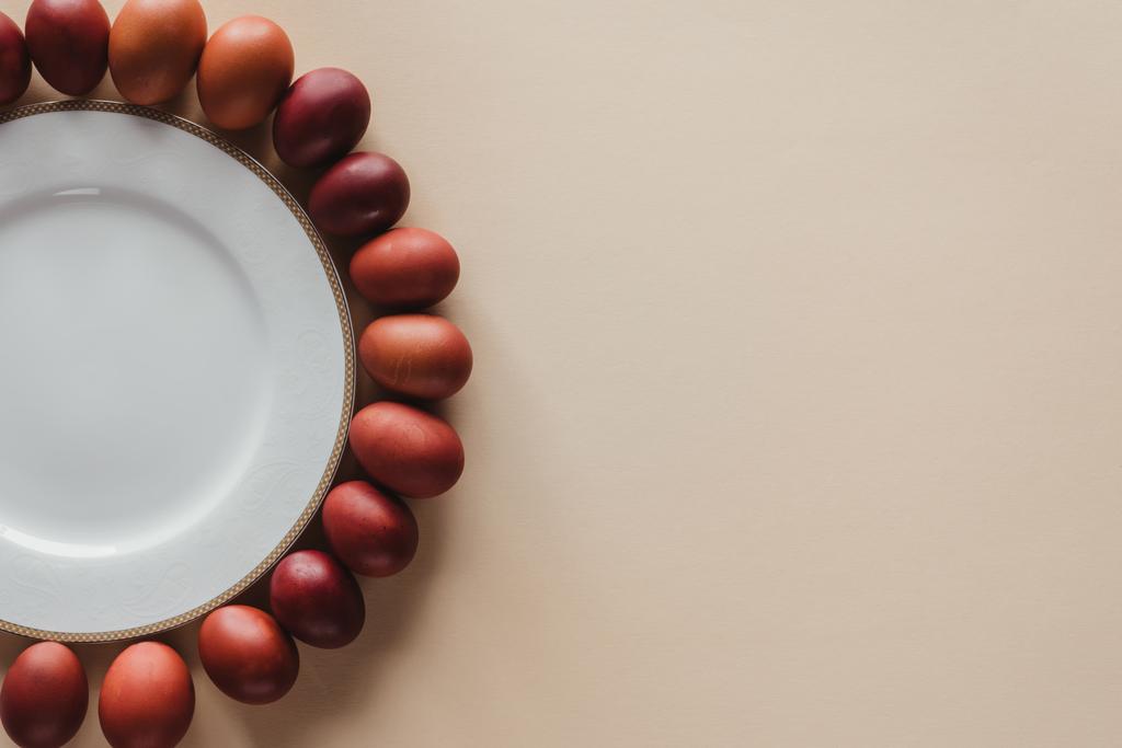 верхний вид куриные пасхальные яйца вокруг тарелки на бежевый с копировальным местом
 - Фото, изображение