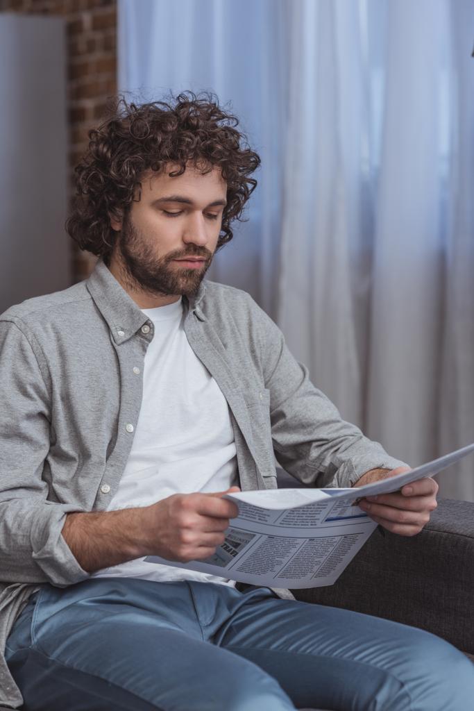 handsome man reading business newspaper in living room - Photo, Image