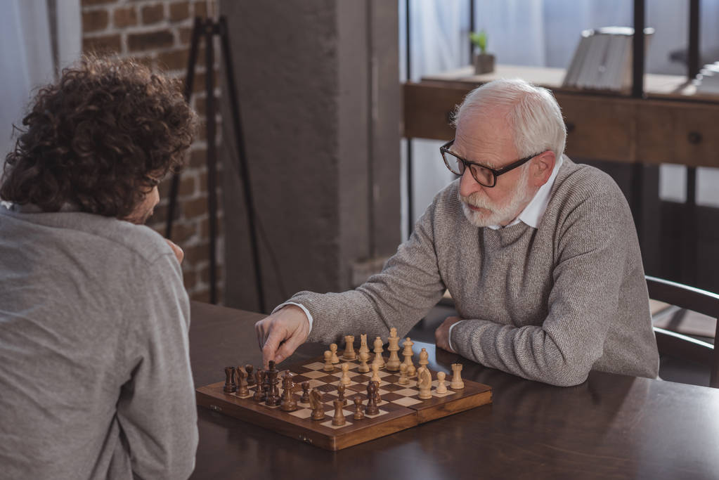 Erwachsener Sohn und älterer Vater spielen zu Hause - Foto, Bild