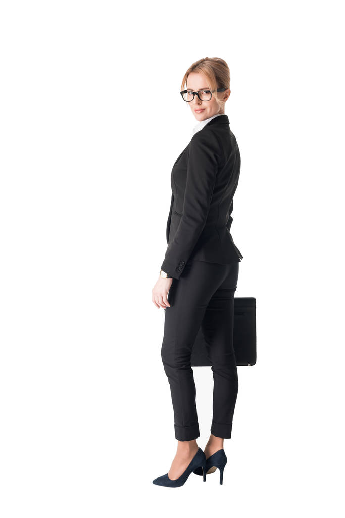 selbstbewusste Geschäftsfrau im schwarzen Anzug mit Aktentasche auf weißem Hintergrund - Foto, Bild
