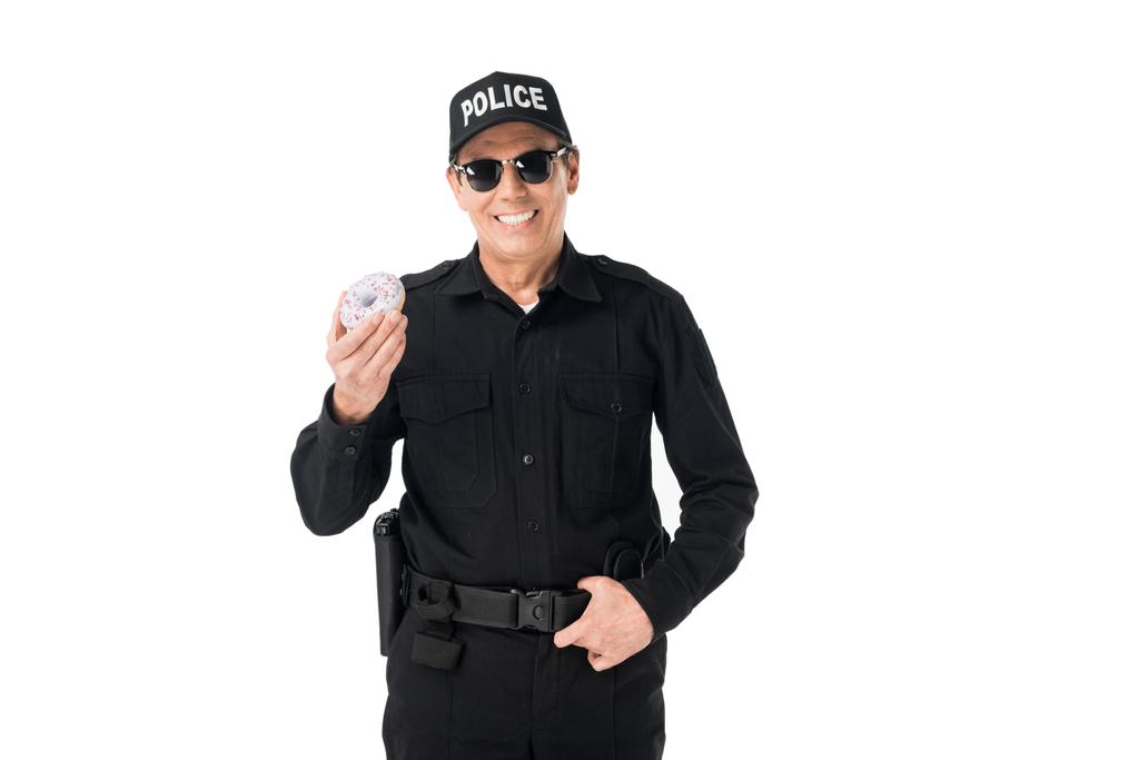 Sorridente poliziotto che tiene ciambella isolata su bianco
 - Foto, immagini