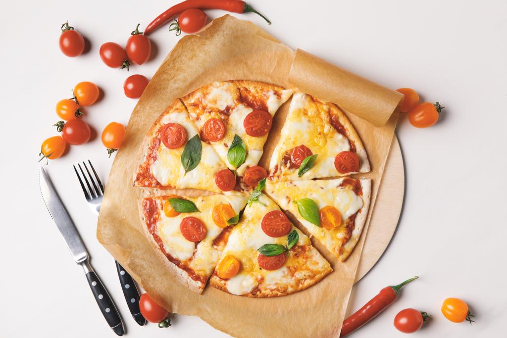 felülnézet étvágygerjesztő ízletes házi készítésű pizzát és cseresznye paradicsom, fehér - Fotó, kép