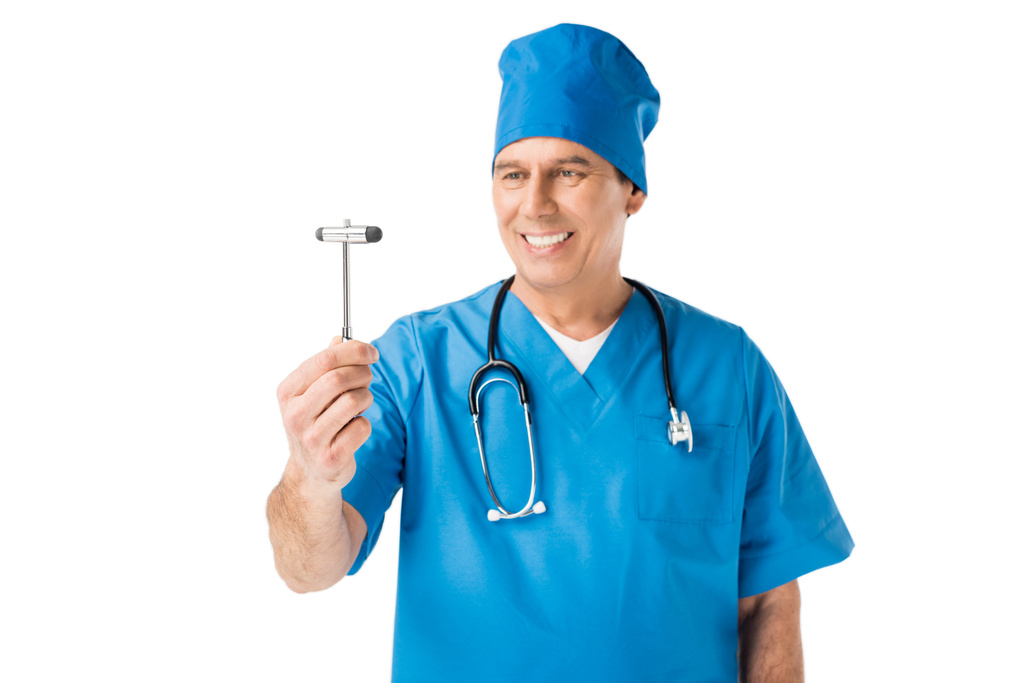Мужчина врач в форме держит рефлекторный молоток изолирован на белом
 - Фото, изображение
