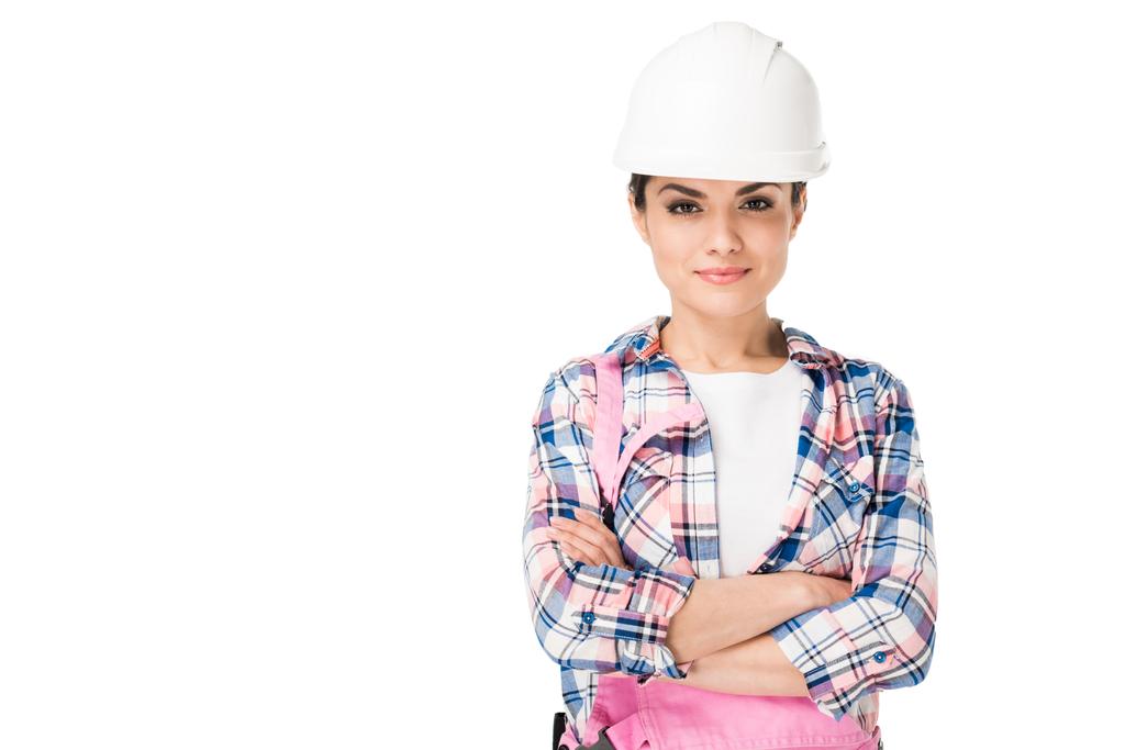 Lachende vrouw bouwvakker in uniform met gevouwen armen op wit wordt geïsoleerd - Foto, afbeelding