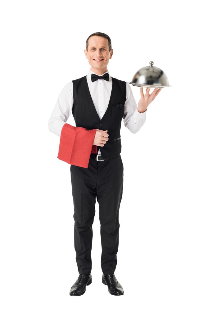 Cameriere professionista sorridente che tiene vassoio di servizio con coperchio isolato su bianco
 - Foto, immagini