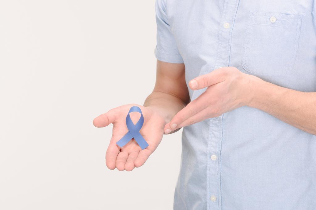 plan recadré de l'homme montrant un ruban bleu de sensibilisation isolé sur blanc, concept de cancer de la prostate
 - Photo, image