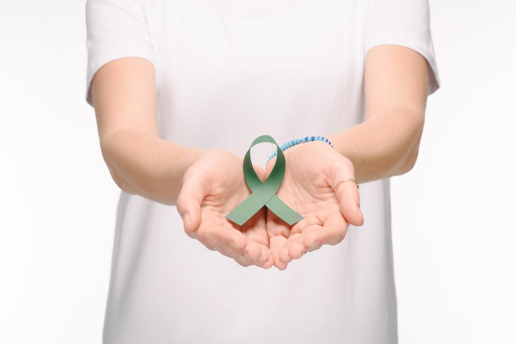 обрізаний знімок жінки, що тримає зелену стрічку для Сколіозу, символ психічного здоров'я в руках ізольований на білому
 - Фото, зображення