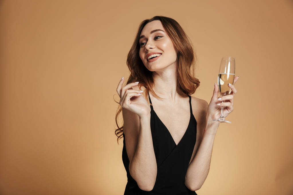 Jeune femme heureuse regardant loin et souriant avec du champagne
 - Photo, image