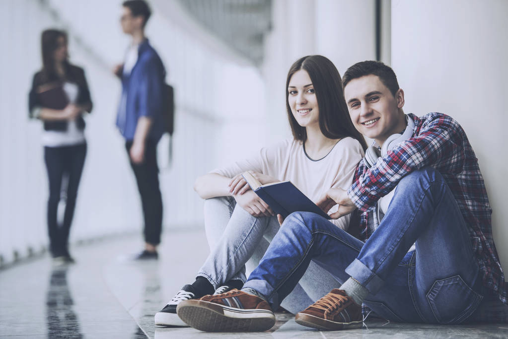 junges Paar Studenten sitzen im Korridor in der Hochschule - Foto, Bild