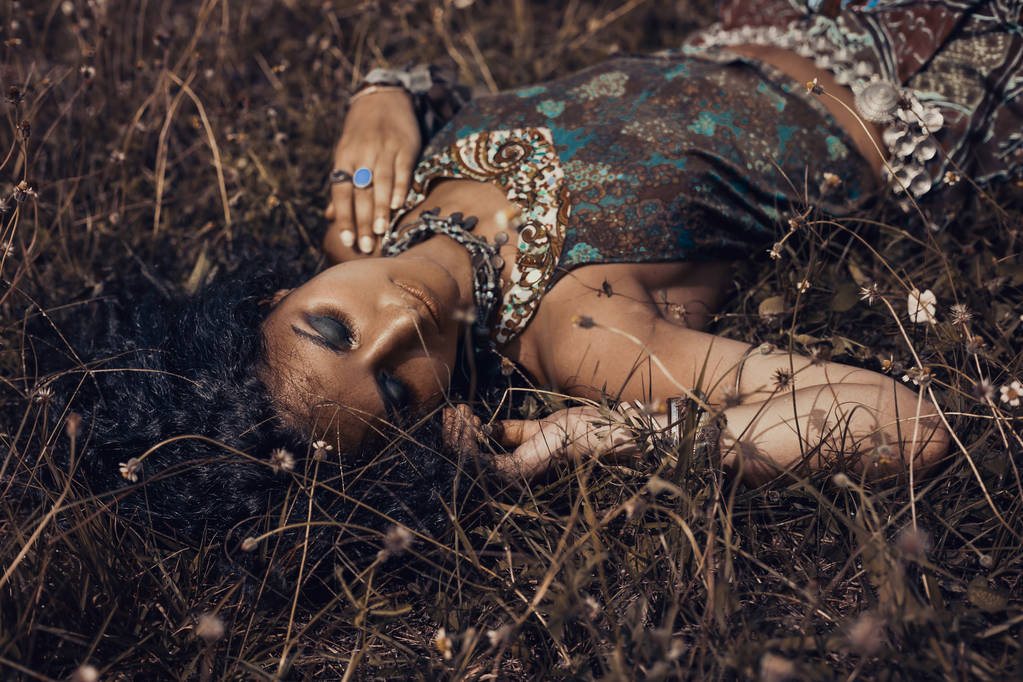 bella giovane ragazza orientale in gioielli etnici sdraiato su un gras
 - Foto, immagini