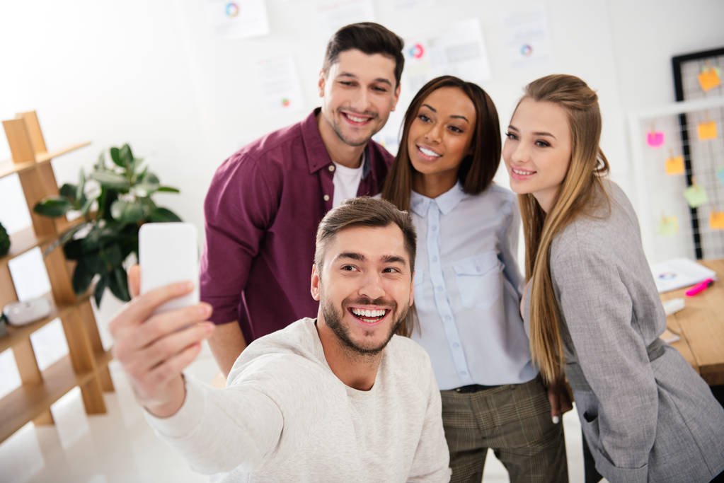 happy multicultural business people taking selfie on smartphone together in office - Photo, Image