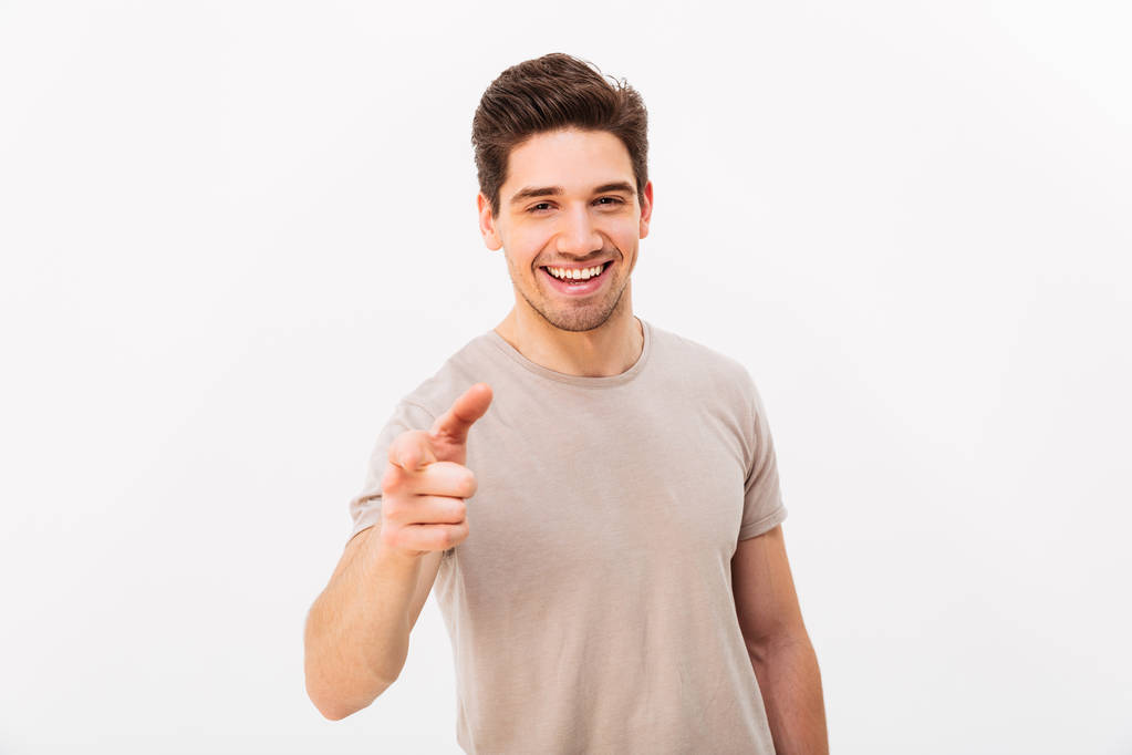 Zelfverzekerde vrolijke man met bruin haar wijsvinger op gebaren - Foto, afbeelding
