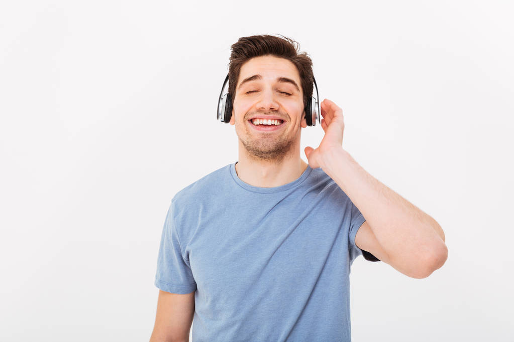 Foto de um cara sorridente adulto com cabelo escuro curto curtindo música
 - Foto, Imagem