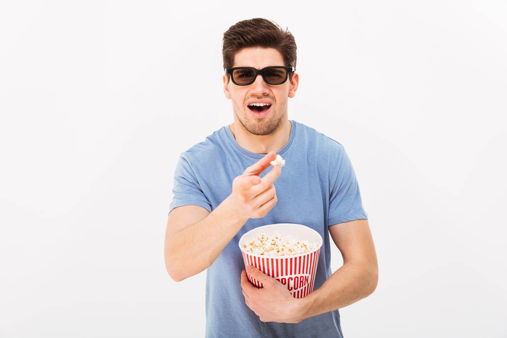 Pohledný muž v ležérní tričko a 3d brýle drží kbelík ŽÁ - Fotografie, Obrázek