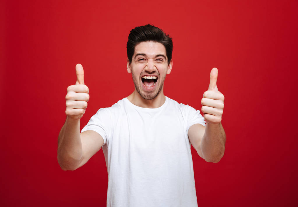 Portret van een vrolijke jongeman in wit t-shirt - Foto, afbeelding