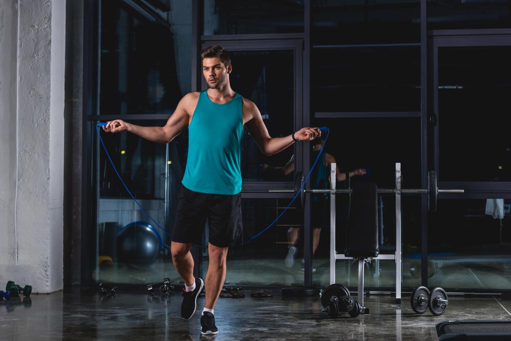 sportsman jumping with skipping rope in gym - Photo, Image