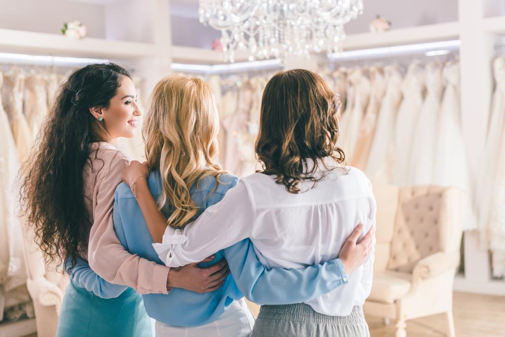  Novias mirando vestidos de encaje en el salón de bodas
 - Foto, imagen