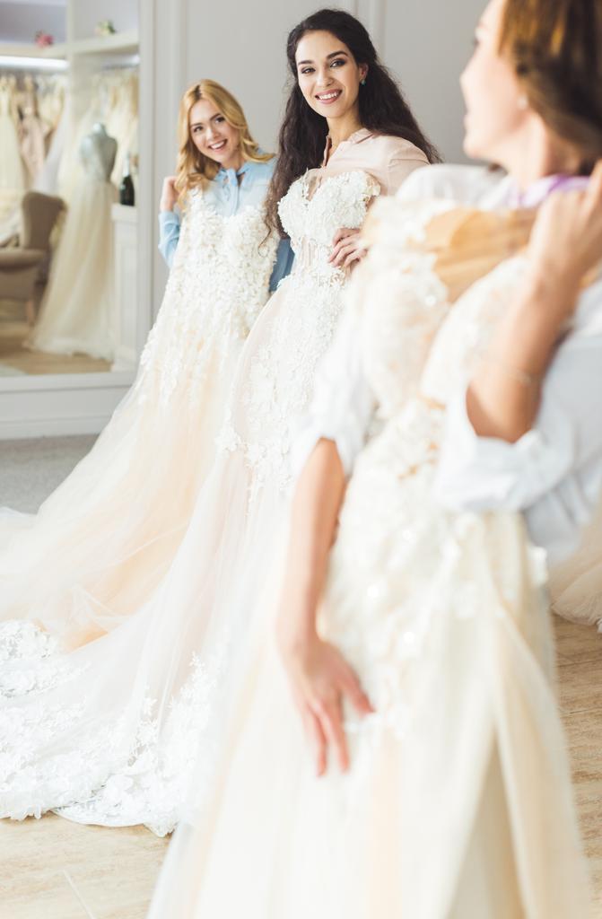Fiatal menyasszony gazdaság műtermében esküvői ruhák - Fotó, kép
