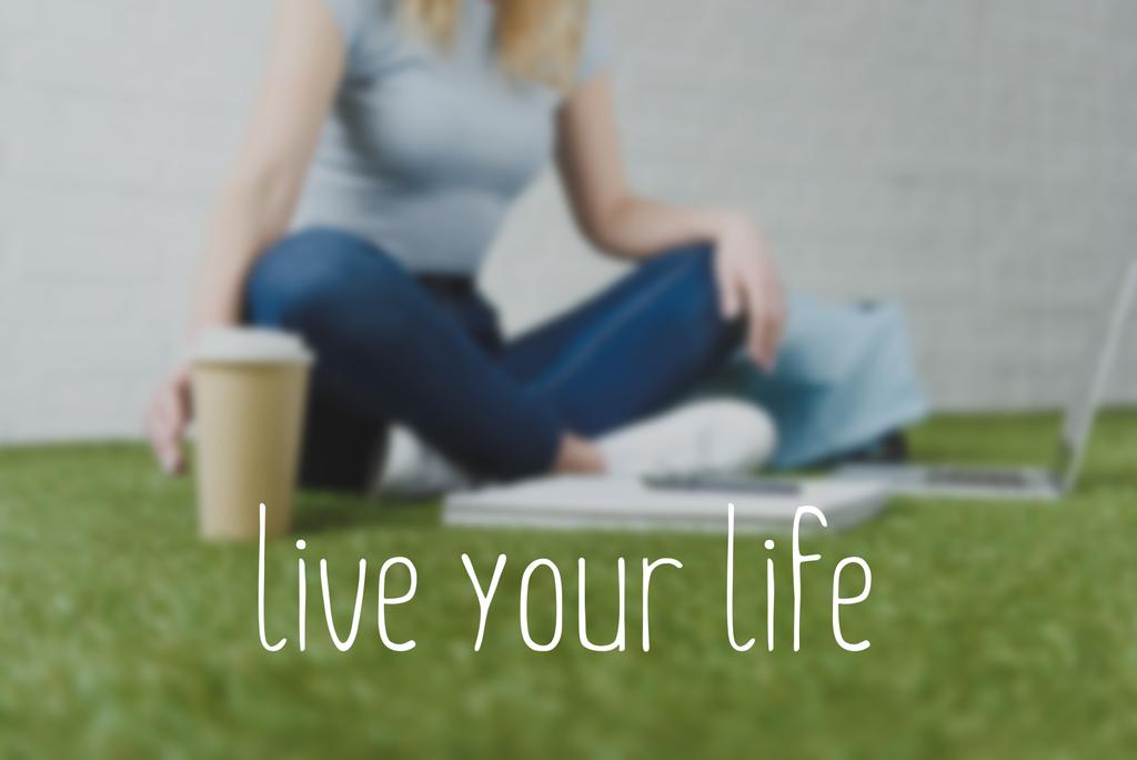 przycięty Zrzut z kobieta siedzi na trawie z filiżanką kawy do pracy z laptopem, żyć swoim życiem napis - Zdjęcie, obraz