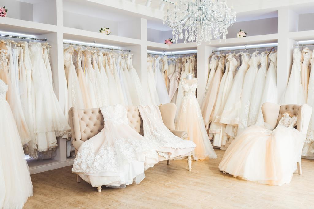 Belos vestidos de noiva em cabides no atelier de casamento
 - Foto, Imagem