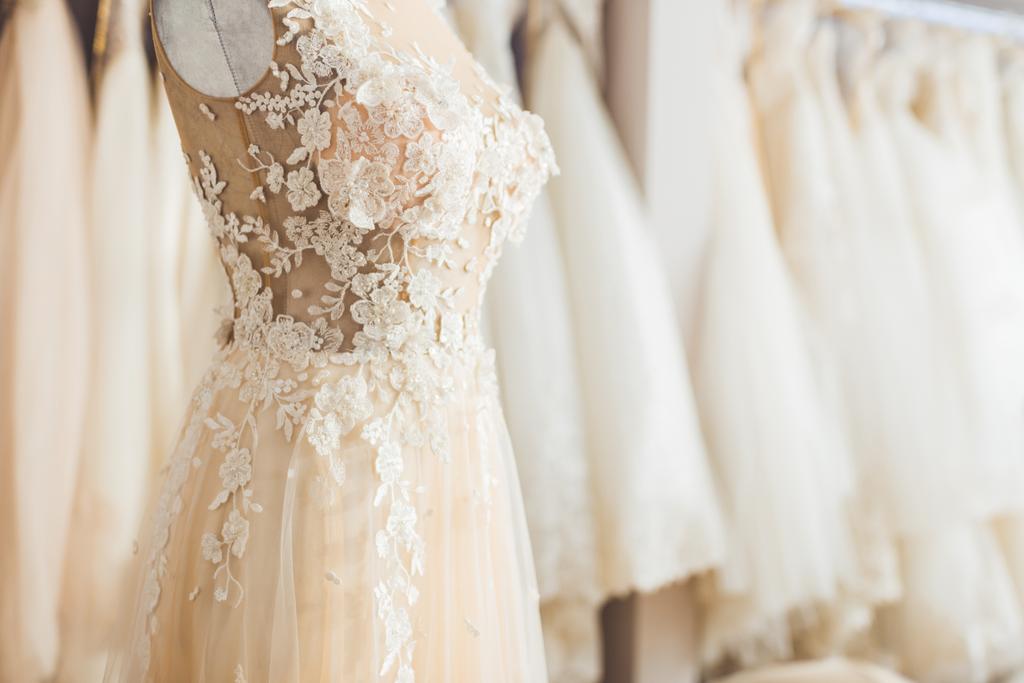 elegantes Spitzenkleid auf Schnuller im Geschäft für Hochzeitsmode - Foto, Bild